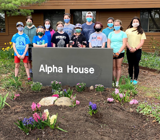 Volunteers plant a springtime ‘Welcome Home’ mat for Alpha House residents